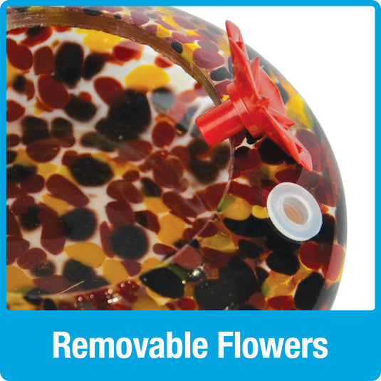 Close up of removable red flower feeding ports on Nature's Way red, yellow and black speckled hand blown glass garden hummingbird feeder