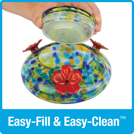 hand lifting the glass lid off of the base dish for easy fill and easy clean on the Nature's Way Illuminated Hummingbird hand blown glass Feeder