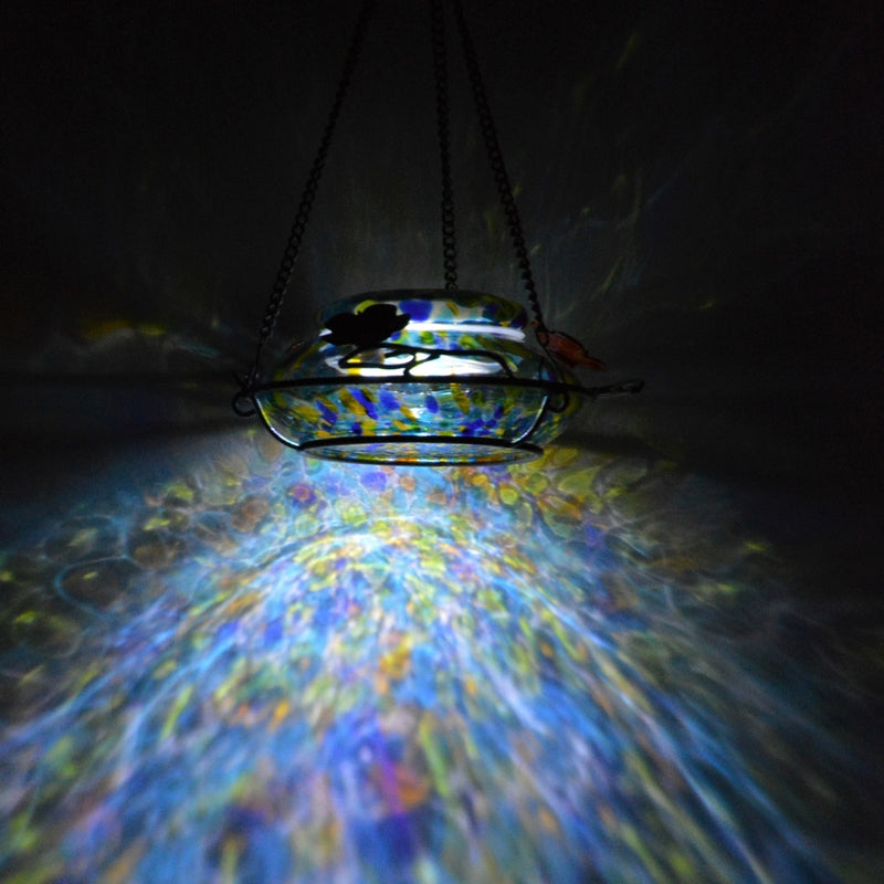 Load image into Gallery viewer, LED light casting pattern on wall with the Nature's Way Illuminated Hummingbird hand blown glass Feeder