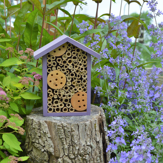 Better Gardens Bee House sitting on stump in garden