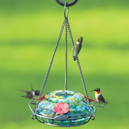 Three hummingbirds feeding from the Nature's Way Illuminated Hummingbird hand blown glass Feeder 