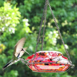 hummingbird landing on decorative leaf perch on the Nature's Way red, yellow and black speckled hand blown glass garden hummingbird feeder