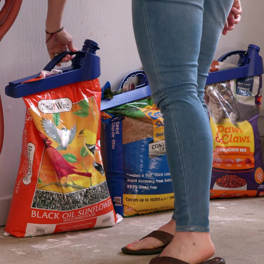 three bags of bird seed, fertilizer and cat food with the handle-it bag clip in a garage