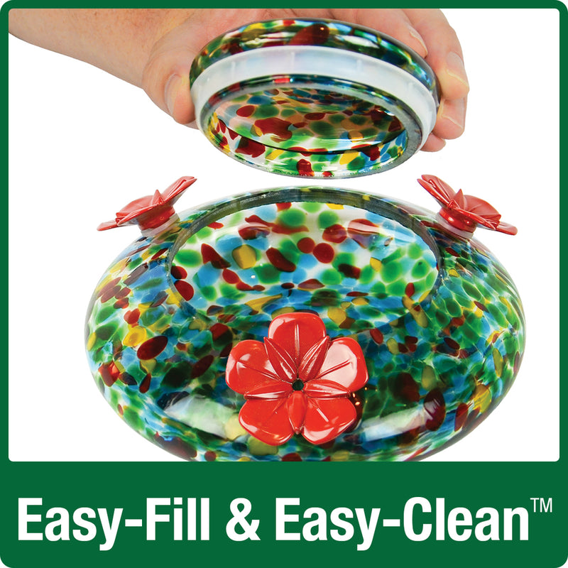 Load image into Gallery viewer, hand lifting the glass lid off of the base dish for easy fill and easy clean on Nature&#39;s Way hand blown glass garden hummingbird feeder in ocean sunset
